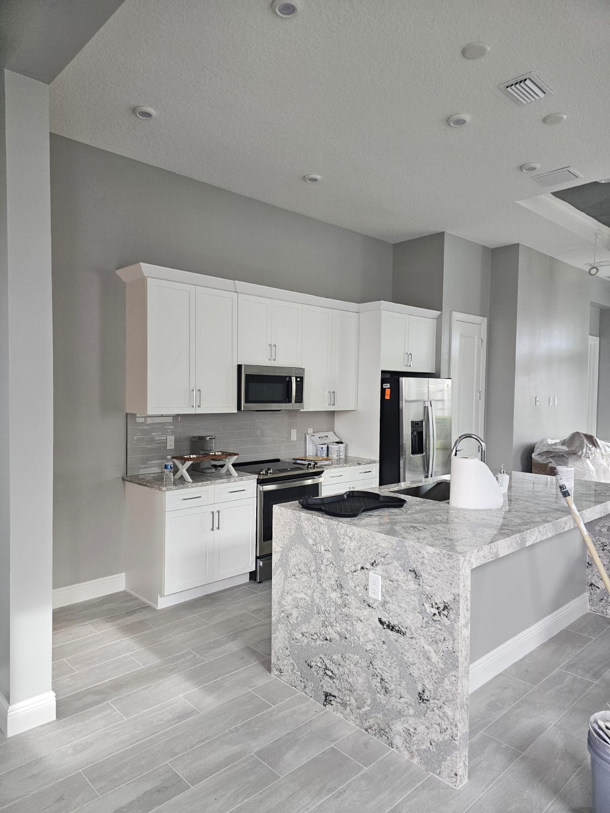 White shaker kitchen cabinets with granite island after refinishing