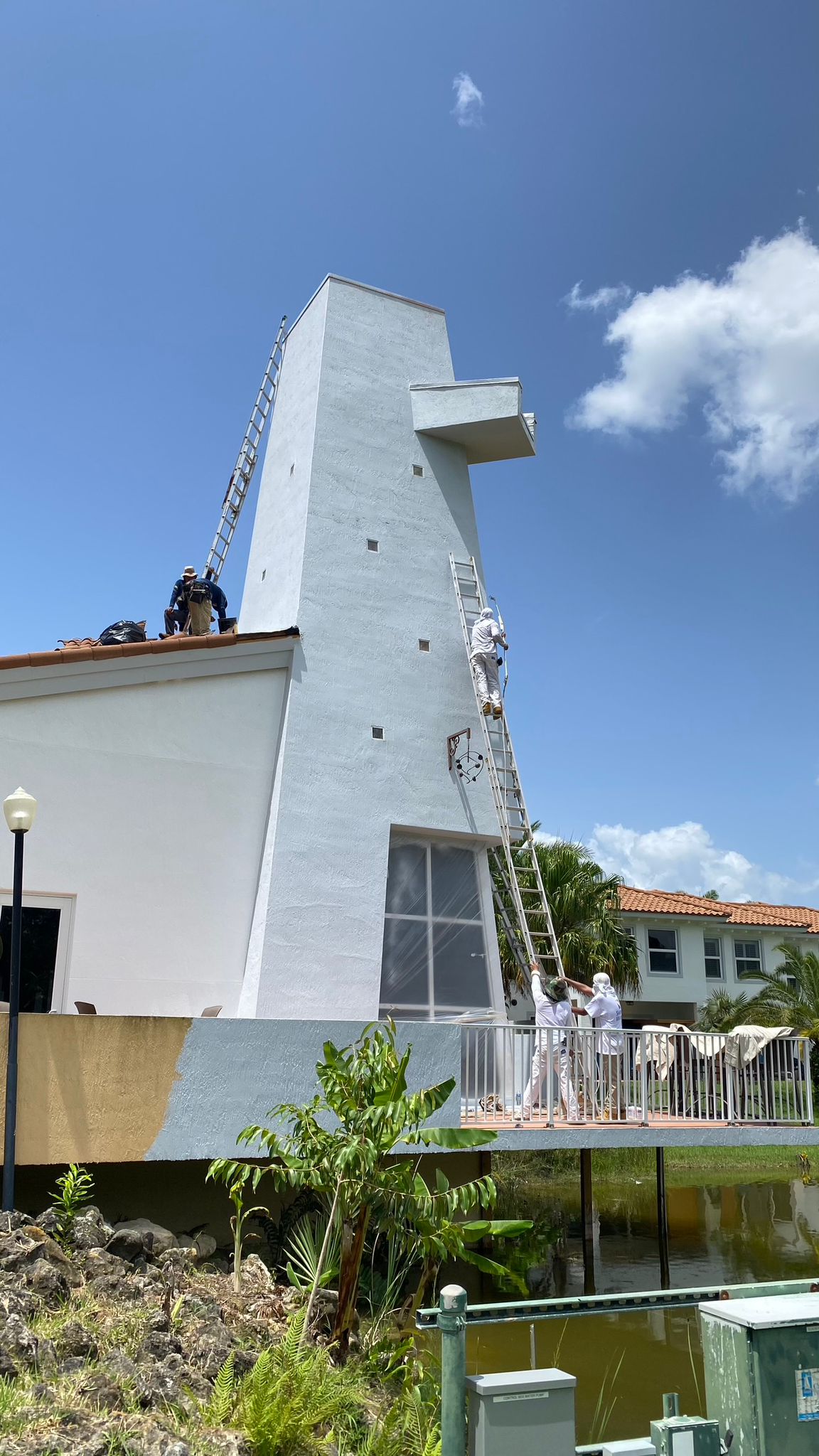 Crew painting tall lakeside commercial tower