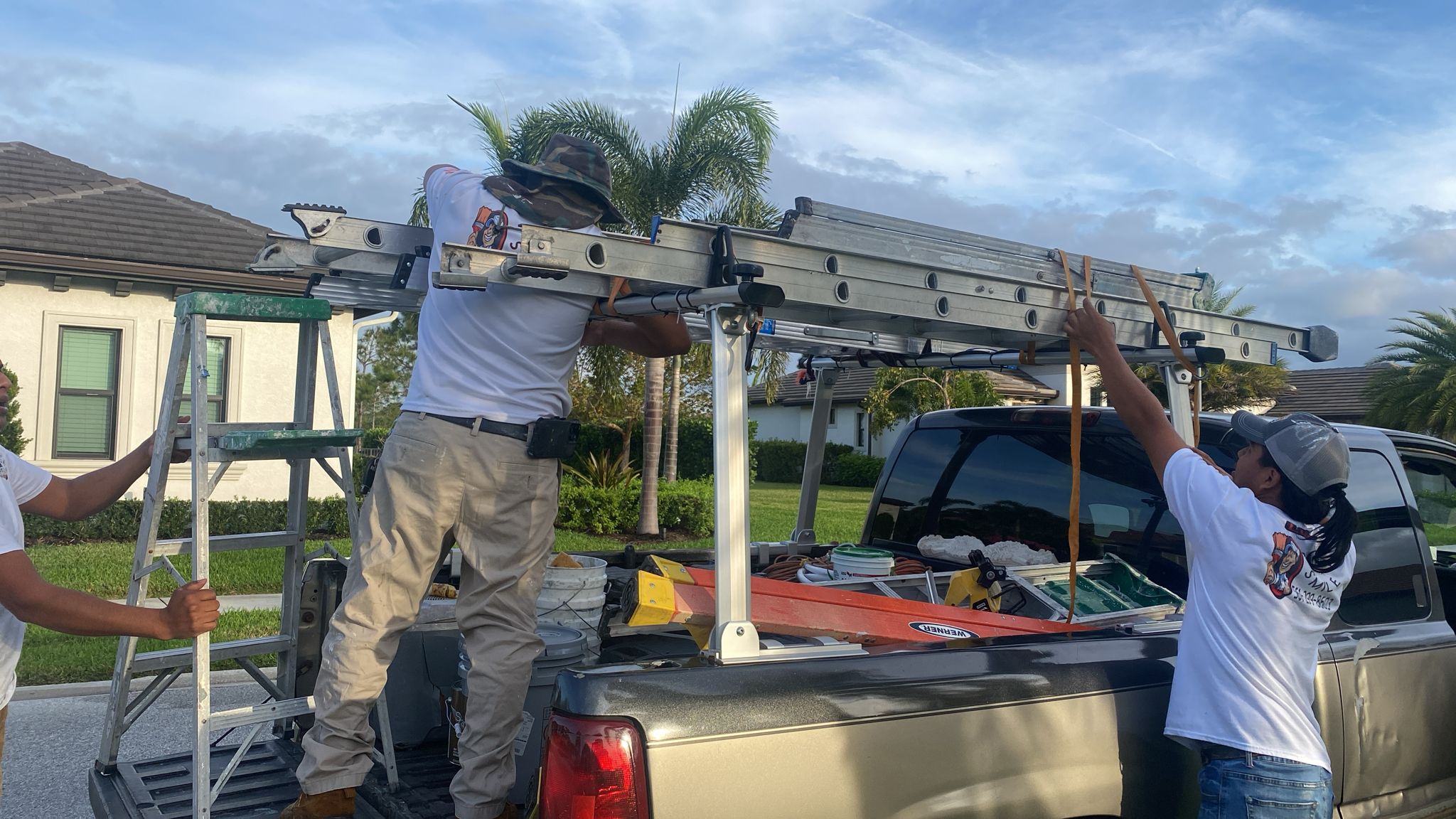 Crew members loading ladders onto the work truck