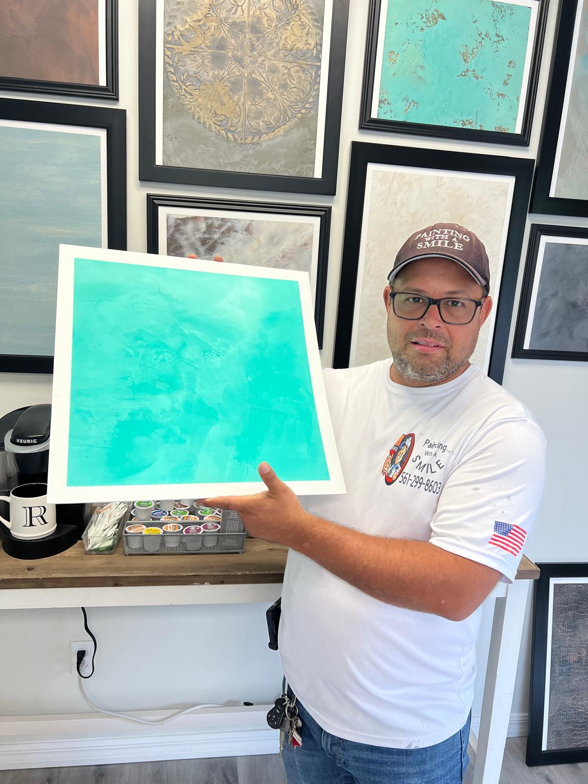 Painting With A Smile team member reviewing a decorative finish sample