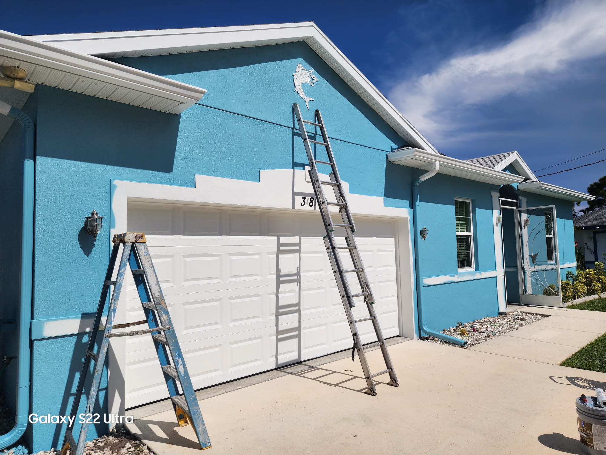 Clean teal house exterior with garage after washing and painting