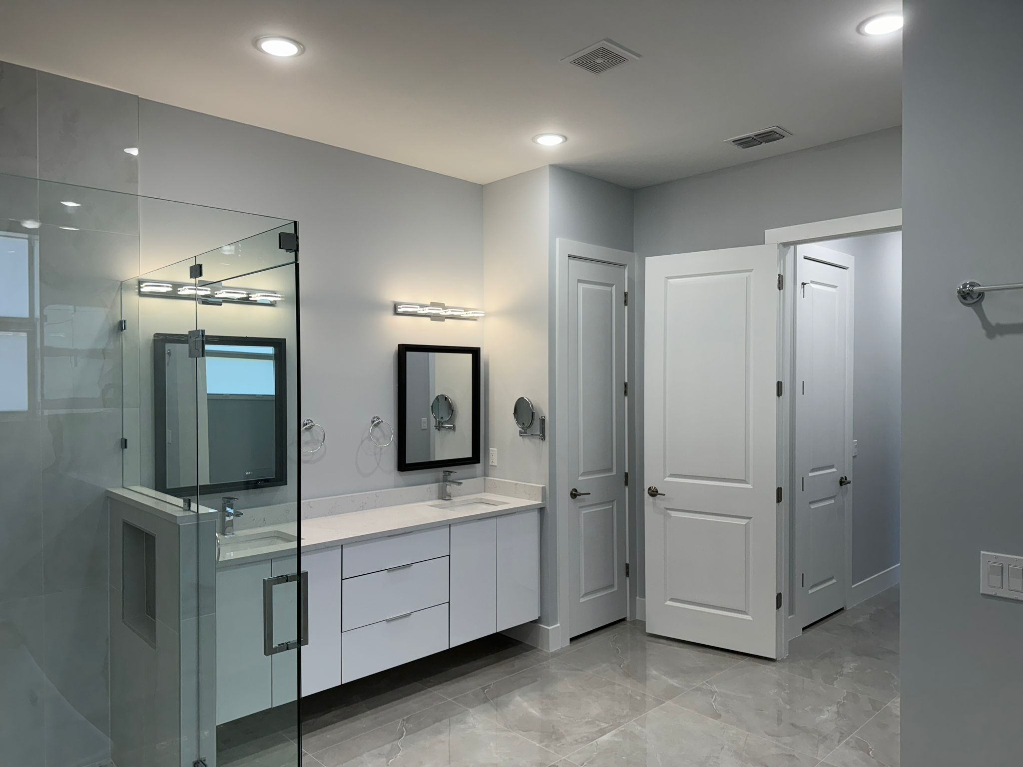 Bathroom vanity and glass shower with fresh white paint
