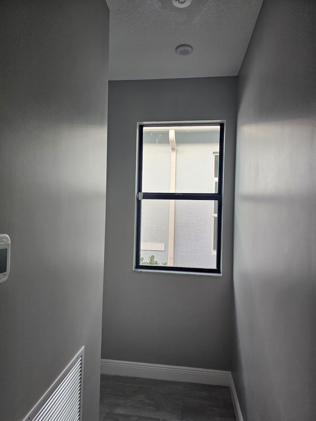Gray painted nook with black window and seamless smooth walls