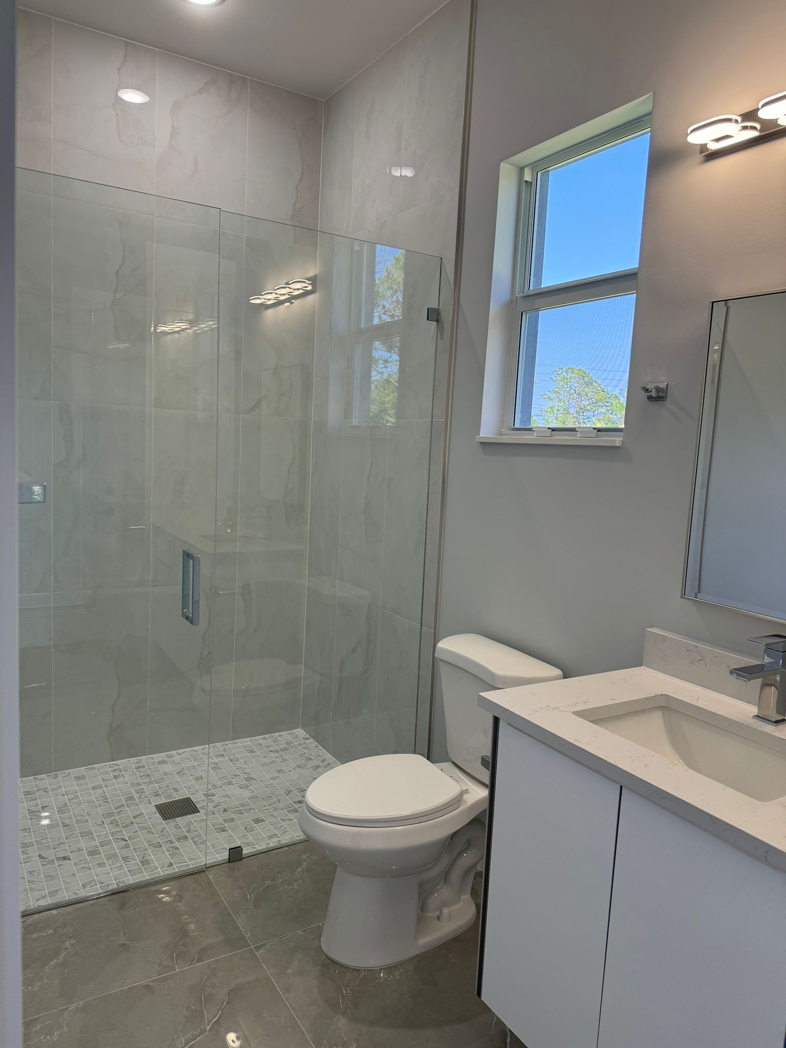 Guest bathroom with walk-in glass shower and white vanity