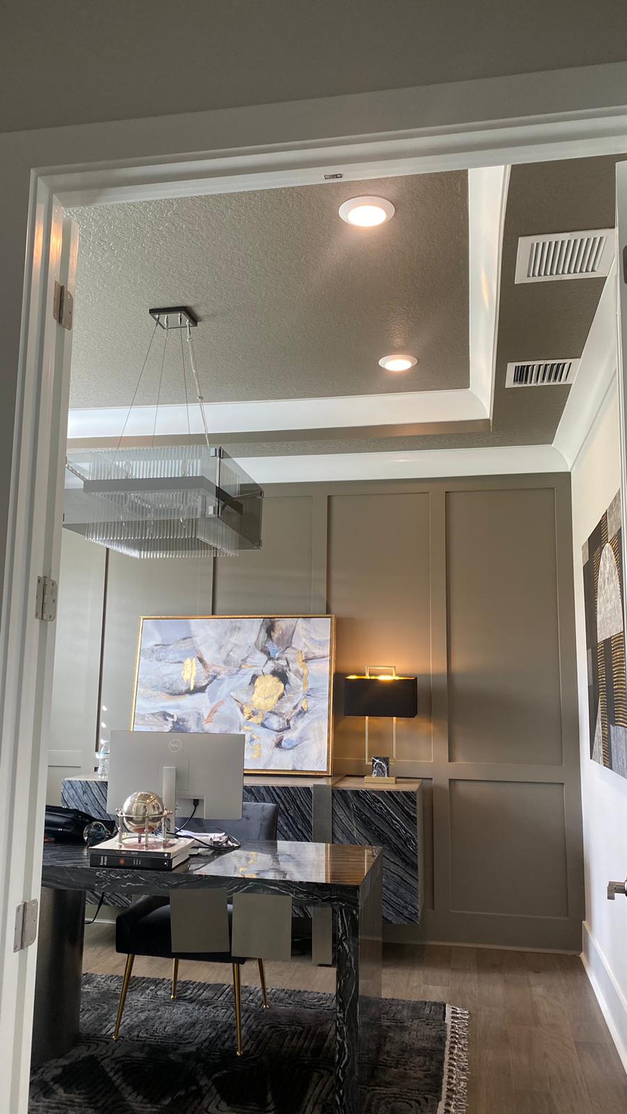 Upscale home office with tray ceiling and wainscot paneling