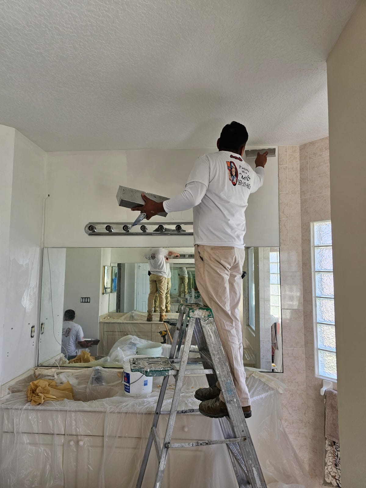 Bathroom wall being skim coated before painting