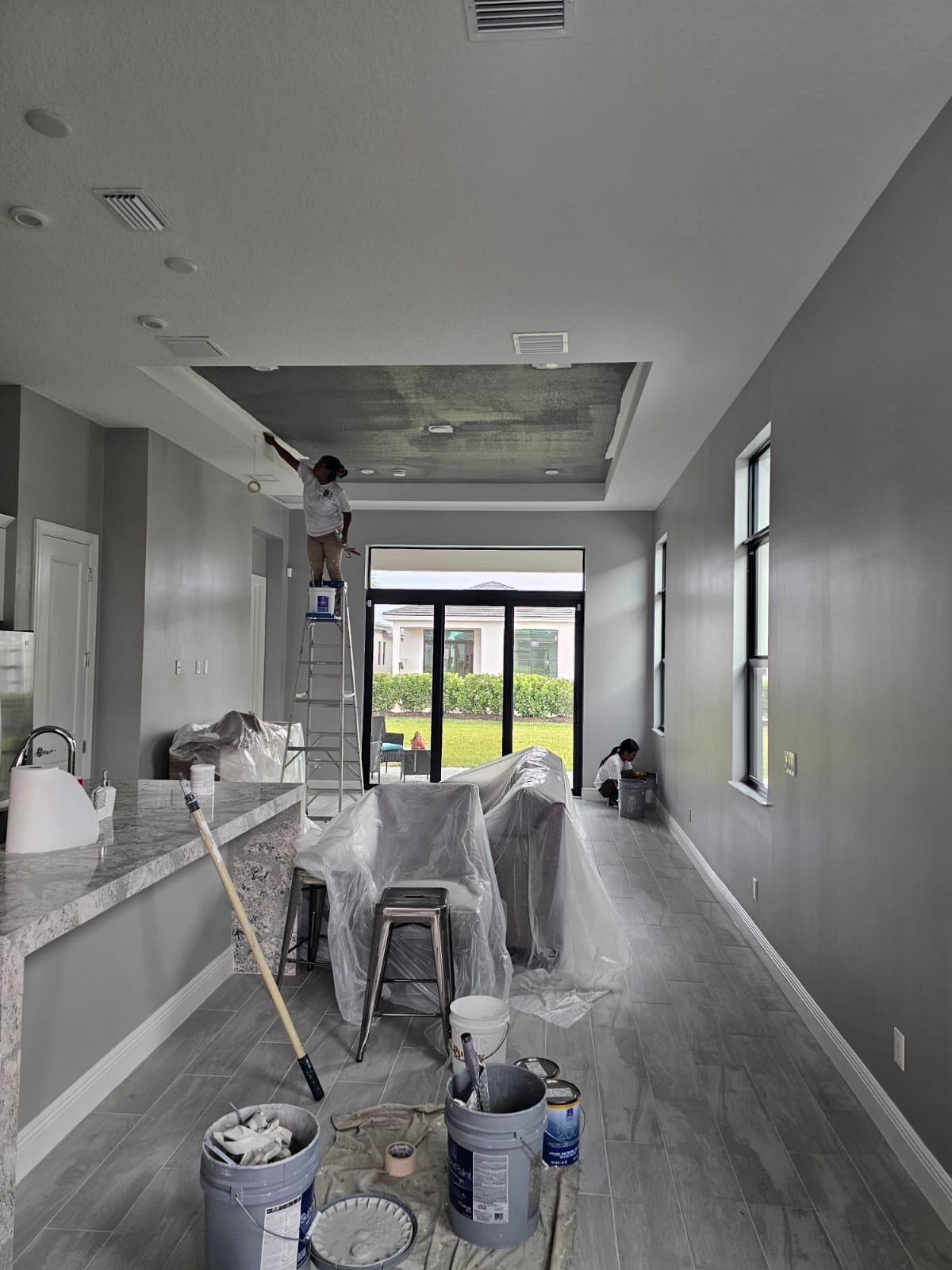 Painter rolling a repaired tray ceiling