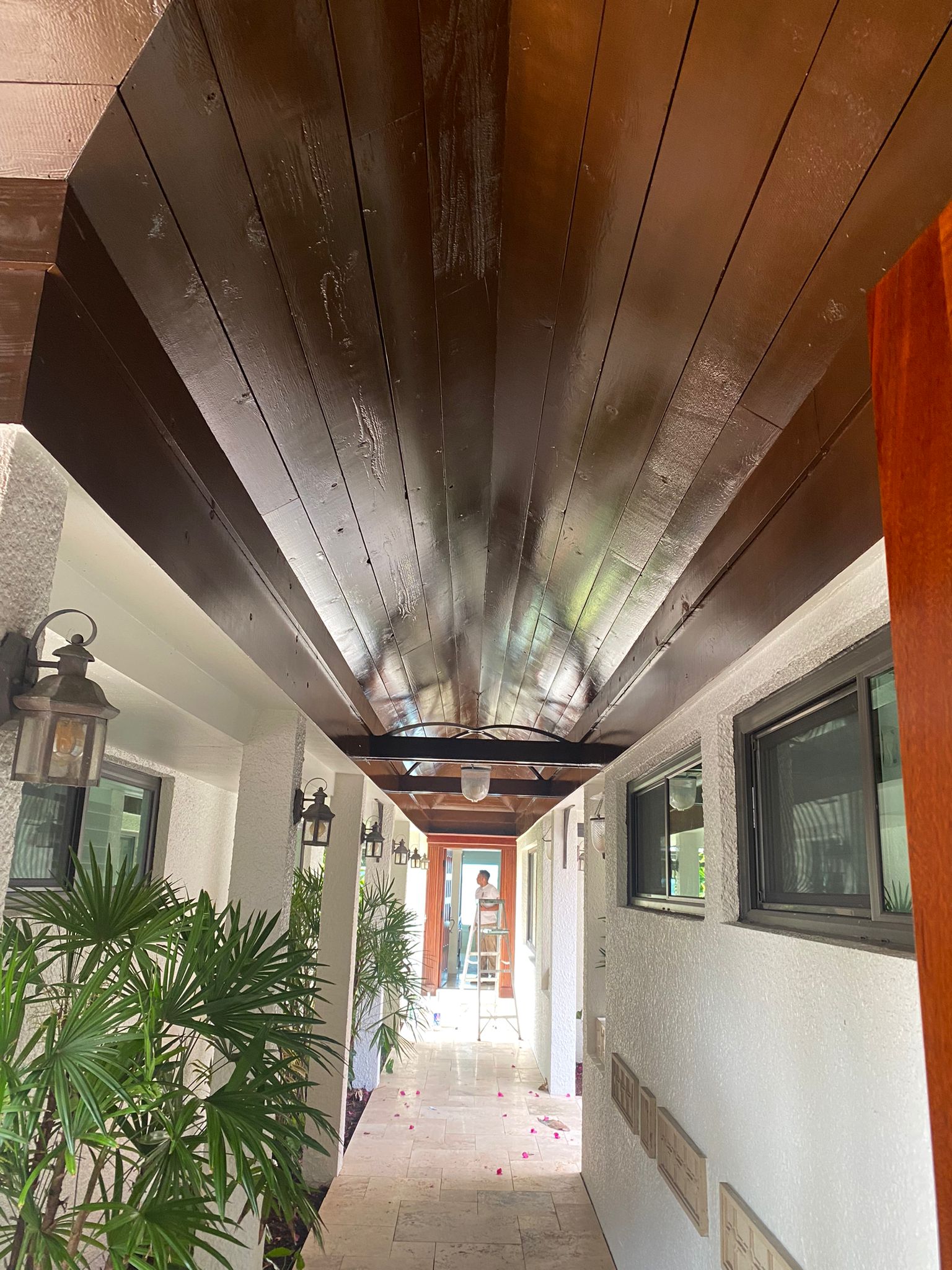 Stained wood plank breezeway ceiling at a tropical entryway