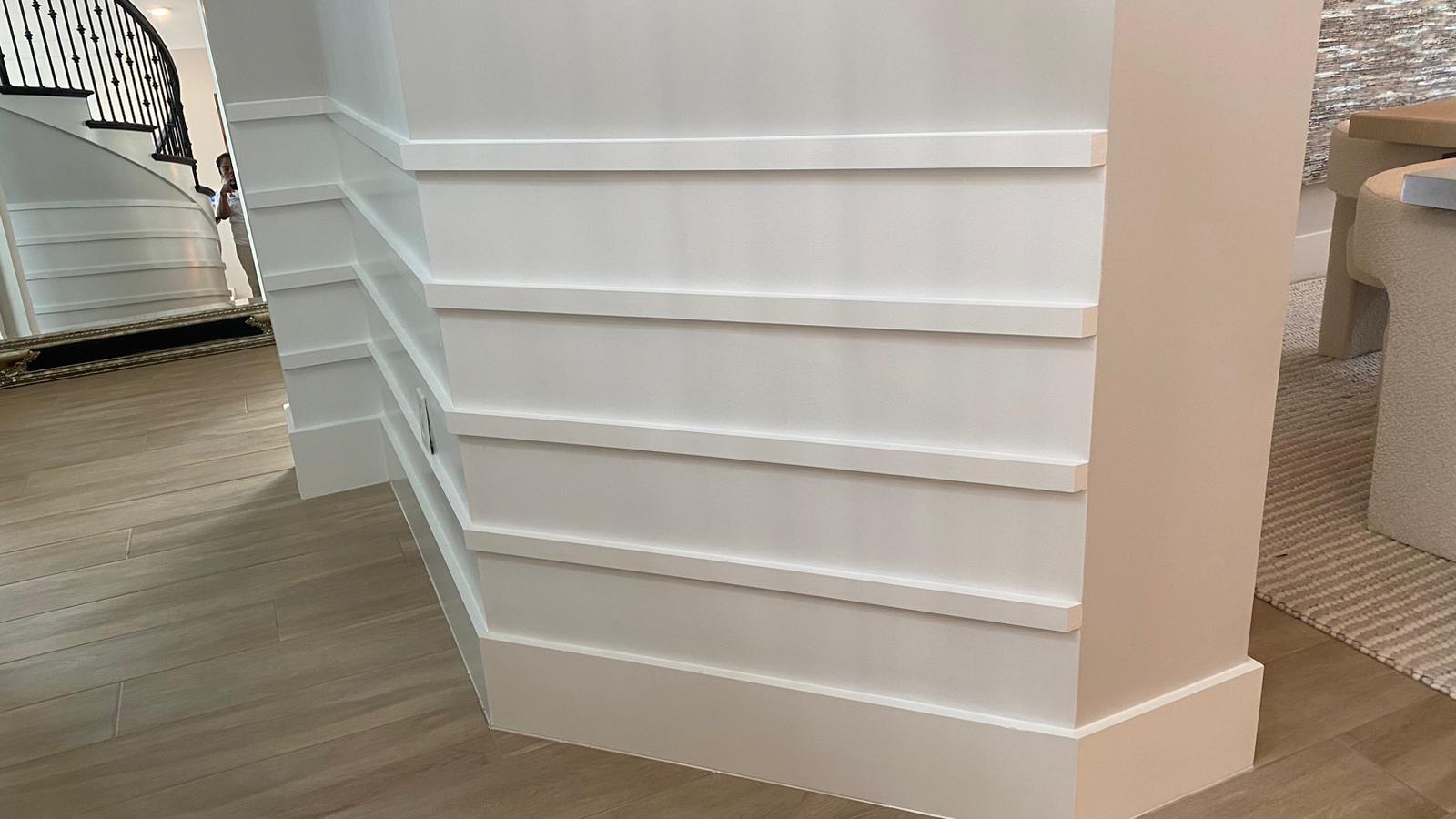 White stepped wainscoting along a staircase wall