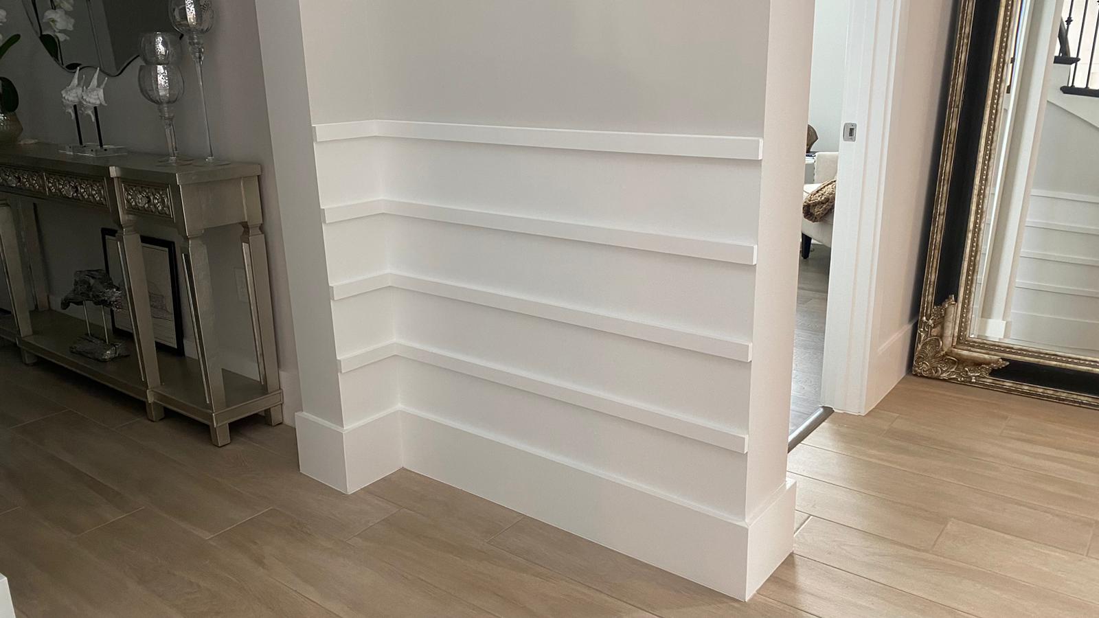 White stepped wainscot trim wall with console table